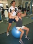 Image of a Personal Trainer training a client on a Swiss Ball.